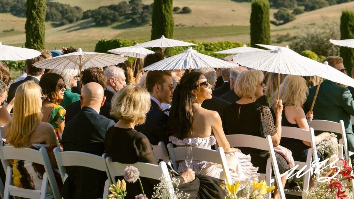Wedding guests seated outdoors during a destination wedding ceremony as photographers capture the event